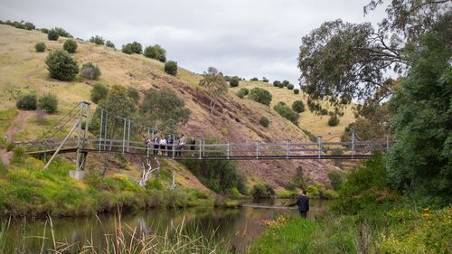 Sandi Mcdonald Prosecutor (centre/white jacket) points down stream over the Onkaparinga River, a location where the accused Dieter Pfennig frequented in his canoe, in Adelaide. (AAP)
