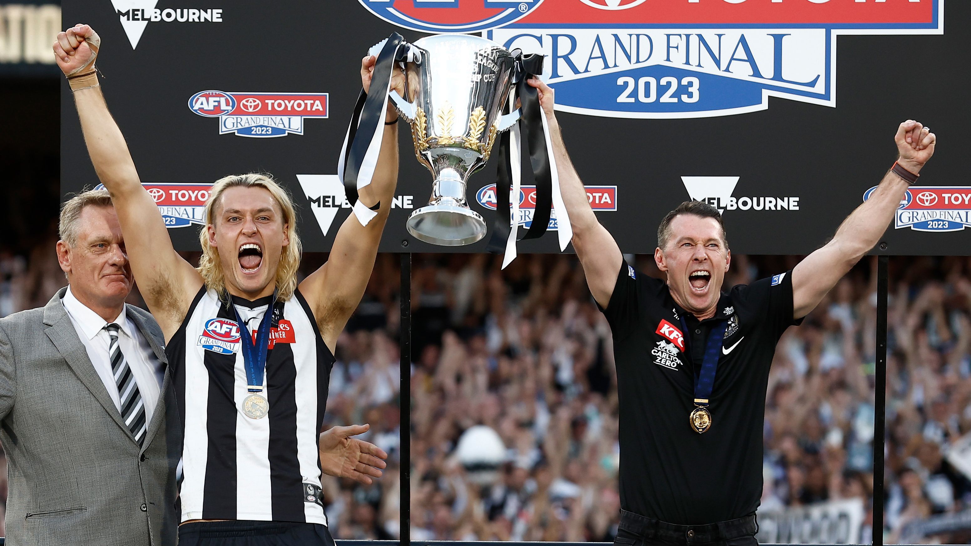MELBOURNE, AUSTRALIA - SEPTEMBER 30: (L-R) Peter Moore, Darcy Moore of the Magpies and Craig McRae, Senior Coach of the Magpies hold the cup aloft during the 2023 AFL Grand Final match between the Collingwood Magpies and the Brisbane Lions at the Melbourne Cricket Ground on September 30, 2023 in Melbourne, Australia. (Photo by Michael Willson/AFL Photos via Getty Images)