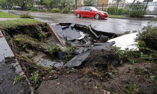 A car travells past a sinkhole in downtown Wilmington, North Carolina, after Hurricane Florence travelled through the area in September 2018.