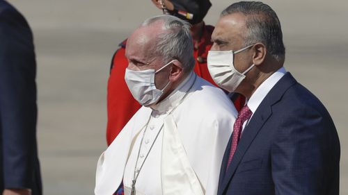 Pope Francis is flanked by Iraqi Prime Minister Mustafa al-Kadhimi upon hi arrival at Baghdad's international airport, Iraq, Friday, March 5, 2021