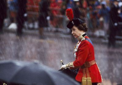 Queen Elizabeth II grimacing in driving rain at the Trooping the Colour ceremony in London on June 12, 1982.