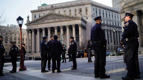 Ofițerii de poliție din New York stau de pază în fața Curții Penale din Manhattan înainte de posibile proteste.