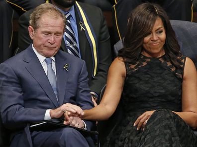 Michelle Obama holds former President George Bush's hand at memorial for five Dallas and DART police officers shot to death in 2016