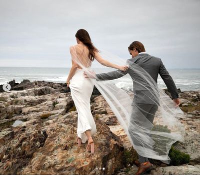 Barbara and husband Craig traverse some rocks to pose for wedding photos.