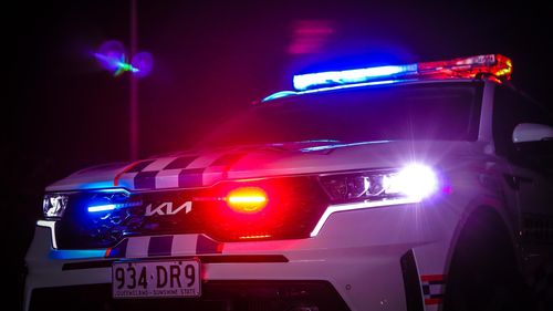 A QLD Kia Police car at night with its sirens on