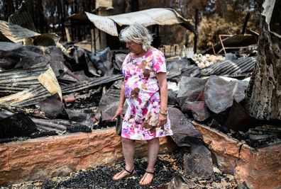 Vanessa Williams stands on the remains of Mogo Pottery, the business she ran with her husband Peter Williams (not pictured) in Mogo, Wednesday, January 15, 2020. Bushfires swept through Mogo on New Years Eve 2019 destroying several homes and businesses. Peter and Vanessa Williams lost both their home and their business which were adjacent to eachother in Mogo. (AAP Image/James Gourley)