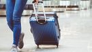 Woman in international airport walking with luggage