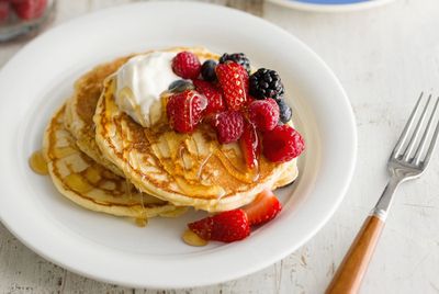 Homemade pancakes with fresh berries, yoghurt and honey