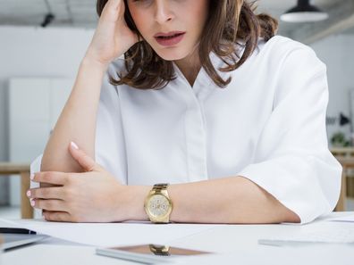 Mulher empresária com dor de cabeça sentada na mesa.  Empresária sob terrível tensão física no trabalho.