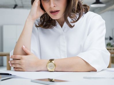 Female entrepreneur with headache sitting at desk. Businesswoman under terrible physical tension at work.