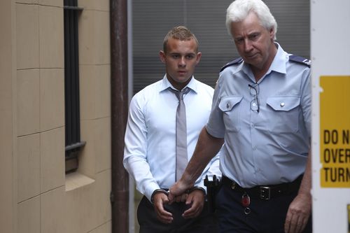 Kieran Loveridge (a sinistra) con le manette viene scortato fuori dalla Corte Suprema del NSW nel 2013.