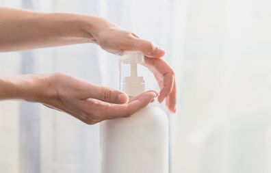 Woman hands pushing pump plastic soap bottle