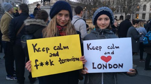 People gathered at the vigil held signs carrying messages of solidarity. (Henri Paget/9NEWS)