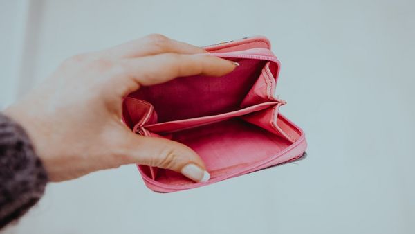 A woman holding open an empty wallet. 