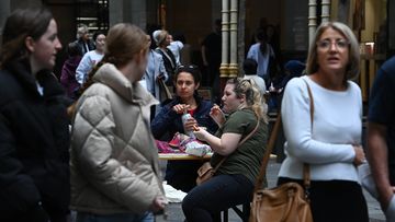 People eat takeaway food in Pitt Street Mall in the CBD of Sydney