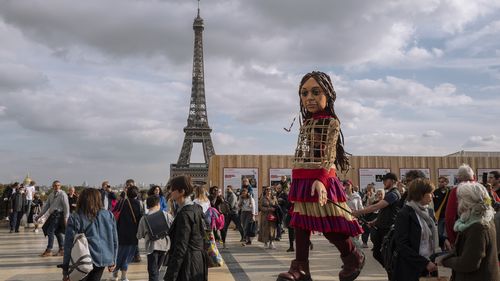 People attend the "Little Amal" show at Trocadero in front of the Eiffel Tower Paris, France, Friday, October 15, 2021.