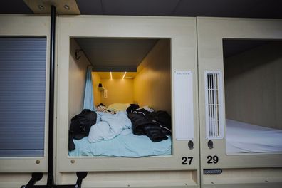 Modern capsule hotel room with comfortable bed, personal belongings, and privacy features, providing convenient and affordable accommodation for budget travelers