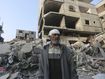 A Palestinian stands outside the building destroyed in the Israeli bombardment of the Gaza Strip