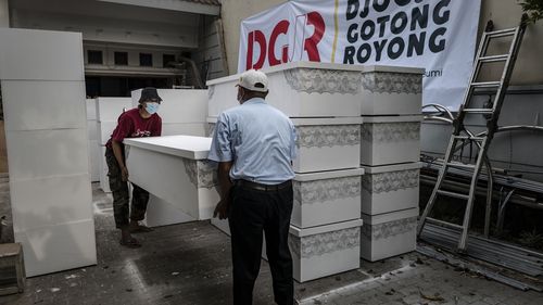 Volunteers of Djogja Gotong Royong loading coffins at a workshop to be distributed to hospitals.