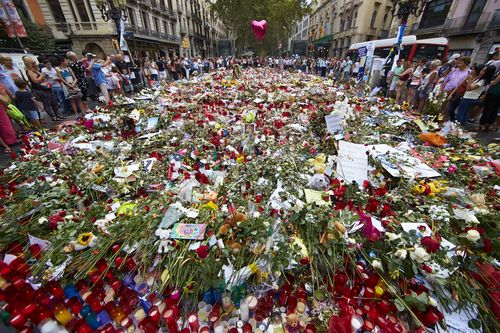 Flowers and candles are placed in tribute to victims of the terrorist attack in Las Ramblas boulevard in Barcelona. (AAP)