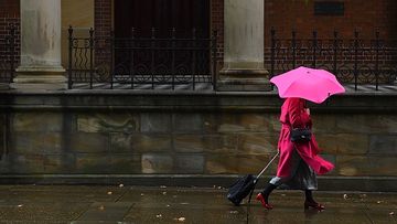 Widespread rain and thunderstorms are predicted for parts of Australia for the next four days.A woman wearing a pink coat and carrying a pink umbrella walks through the rain past St James Church in the Sydney CBD, NSW. 17th March, 2021. Photo: Kate Geraghty