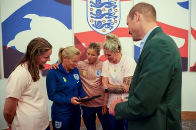 Prince William, Prince of Wales and President of The Football Association, gives an honorary CBE to England manager Sarina Wiegman (2ndL) during a visit to England Women's team to wish them luck ahead of the 2023 FIFA Women's World Cup at St Georges Park on June 20, 2023 in Burton-upon-Trent, England