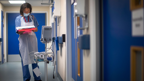 A doctor checks their notes as the first patients are admitted to the Seacole Centre, a converted old military hospital in Surrey, England, in May.