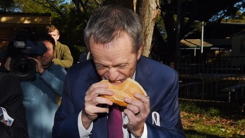 Mr Shorten was mocked last year for biting down into the middle of his sausage. (AAP) 