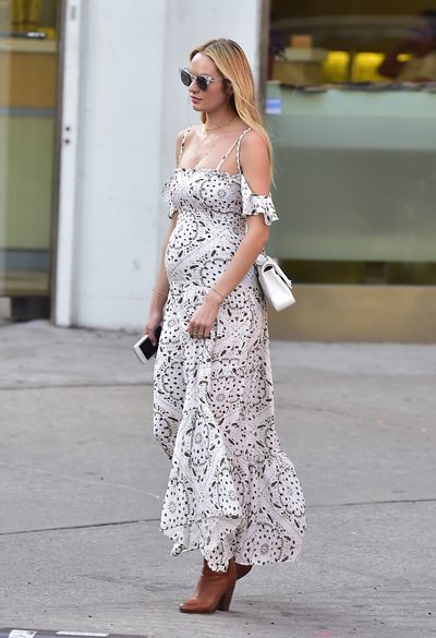 <p>Victoria's Secret angel Candice Swanepoel takes the classic pregnancy staple the maxi dress and gives it a fresh update with a pair of heeled boots, mini tote bag and transparent glasses.</p>
<p>&nbsp;</p>