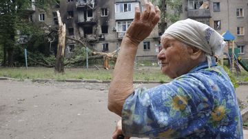 A woman gestures near an apartment building damaged during shelling in Donetsk, in territory under the government of the Donetsk People&#x27;s Republic, eastern Ukraine, Wednesday, June 22, 2022. 