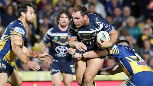 Bolton (centre) breaks a tackle in a game against the Parramatta Eels.