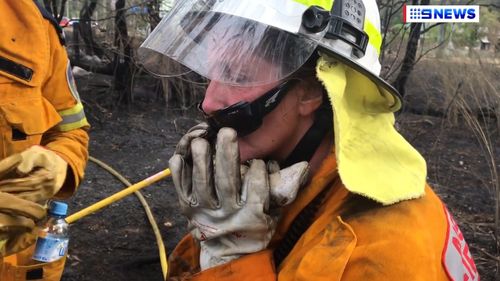 One of the volunteers put the lizard to her face to check whether its body temperature was dropping. (Josh Martin/9NEWS)