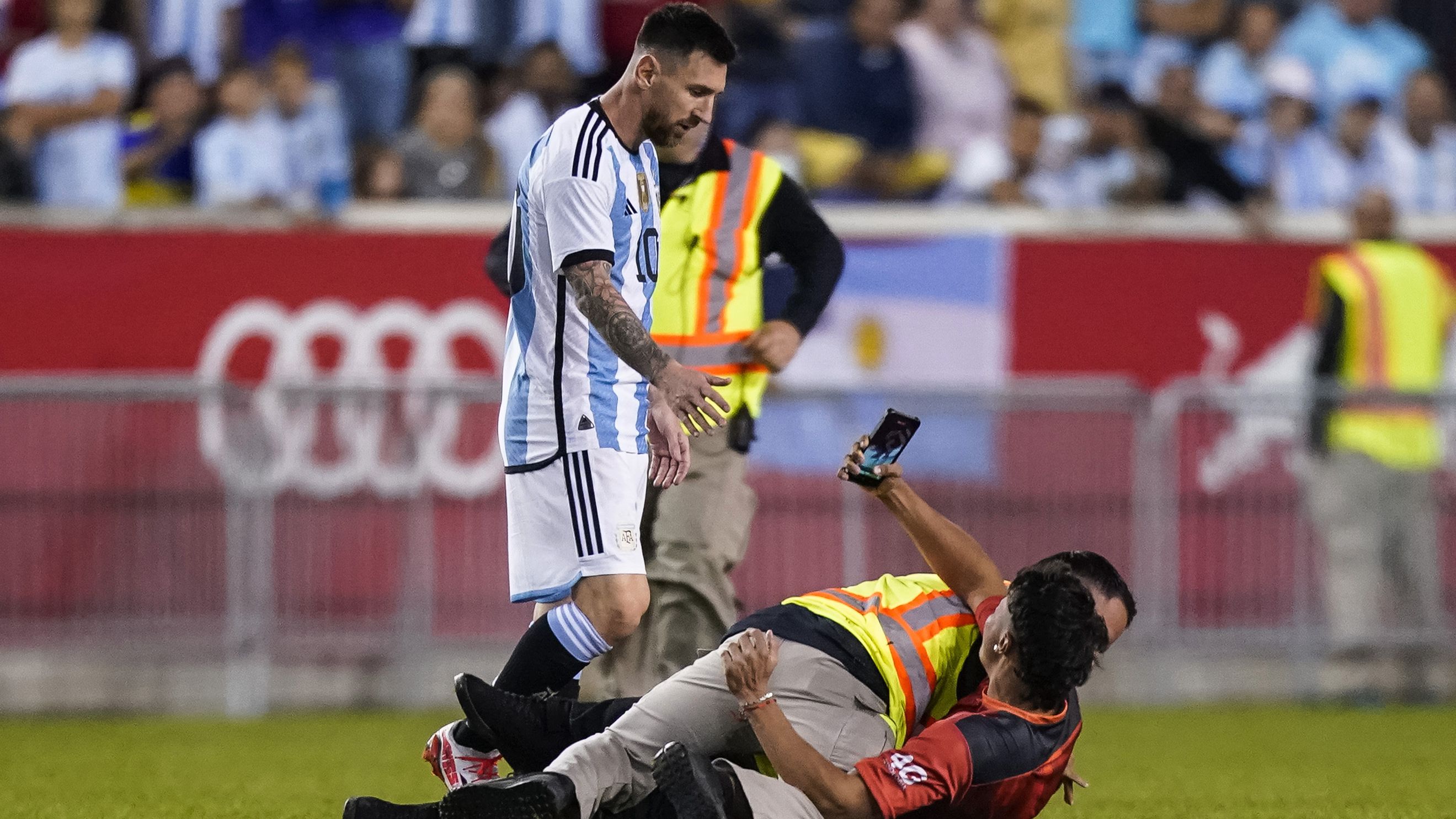 A fan is tackled as he tries to take a picture of Argentina&#x27;s Lionel Messi.