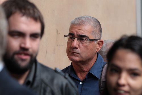 Bill Vlahos (centre) arrives at the Melbourne Magistrates Court in Melbourne, Monday, March 19, 2018. Disgraced racing identity Bill Vlahos faces a committal hearing for hundreds of charges over an alleged punting scam.