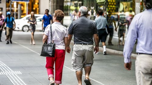 Two old people walk down the street in Brisbane