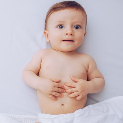 Baby lying on bed and enjoy in warmth of the sheets