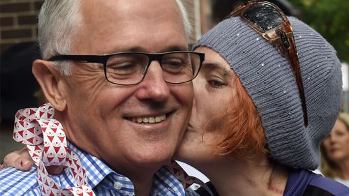 Malcolm Turnbull is kissed by Lynda Hocking at the Wayside Chapel Christmas Day Street Party. (AAP)