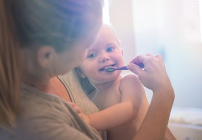 A stock photo of a Toddler (boy) having is teeth brushed with the help of his Mother. Photographed using the Canon EOS 1DX Mark II.