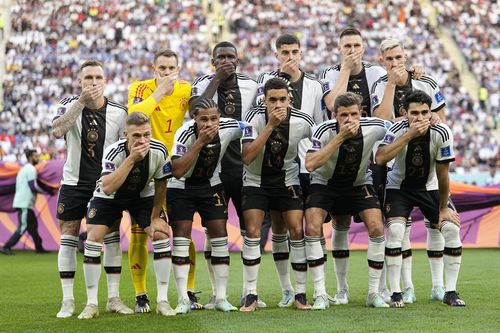 Players from Germany pose for the team photo while covering their mouths during the World Cup Group E football match between Germany and Japan, at the Khalifa International Stadium in Doha, Qatar, Wednesday, November 23, 2022.