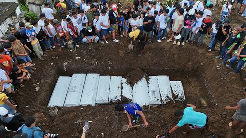 Families gather during the burial of earthquake victims at the New Corazon Cemetery in Bogo City, Cebu province, central Philippines on Wednesday, Oct. 8, 2025. 