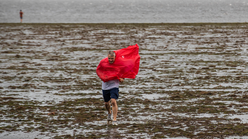 Curious sightseers walk in the receding waters of Tampa Bay in Florida due to the low tide and tremendous winds from Hurricane Ian. (Willie J. Allen Jr./Orlando Sentinel via AP)