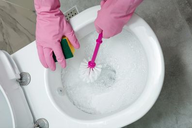 woman cleaning toilet