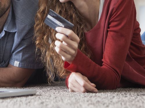 Woman holding credit card next to husband