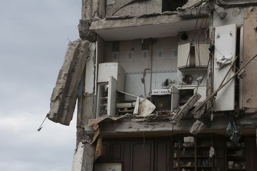 A part of an apartment is seen at the side of damaged during heavy fighting buildings in Mariupol, in the territory under the government of the Donetsk People's Republic, eastern Ukraine, Friday, May 13, 2022. 