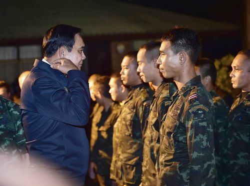 The Thai PM talks to military personnel involved in the rescue mission. Picture: AP