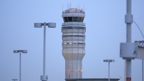 The air traffic control tower at Ronald Reagan Washington National Airport is pictured, Friday, Jan. 31, 2025, in Arlington, Va., near the wreckage of a mid-air collision between a Black Hawk helicopter and an American Airlines jet in the Potomac River. (AP Photo/Alex Brandon)