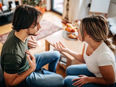 Woman and man sitting on couch fighting