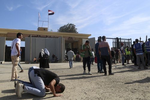 Volunteers pray to thank God after trucks carrying humanitarian aid for the Gaza Strip crossed the Rafah border gate, in Rafah, Egypt, Saturday, Oct. 21, 2023.  