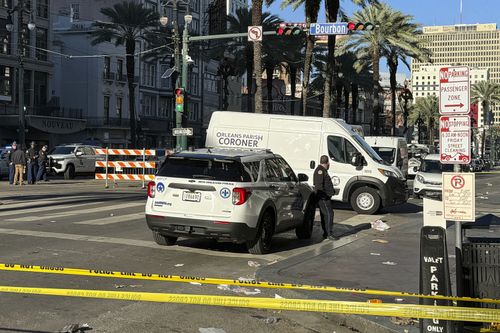 A coroner's van is parked on the corner of Bourbon St. and Canal St, after a vehicle raced into a crowd of revelers early on New Year's Day, in New Orleans on Wednesday, Jan. 1, 2025.