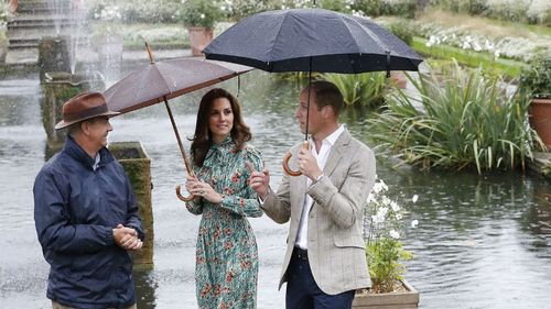 Prince William, right, and his wife Kate, Duchess of Cambridge are given a tour at the memorial garden in Kensington Palace. (AAP)